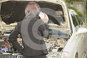 Busuness woman with her broken car, calling for assistance