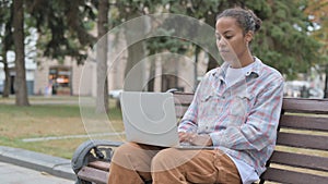 Busy African Woman Using Laptop Sitting Outdoor on Bench