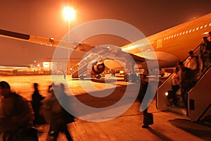 Busy airport at night. Hurry passangers.