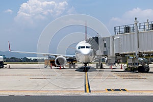 A busy airport tarmac runway with various commercial aircraft planes parked near the terminals