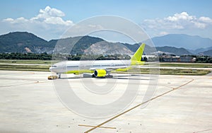 A busy airport tarmac runway with various commercial aircraft planes parked near the terminals