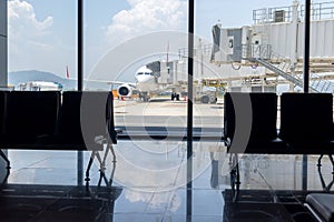 A busy airport tarmac runway with various commercial aircraft planes parked near the terminals