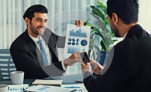 Busy analyst team discussing financial data on laptop and phone. Fervent