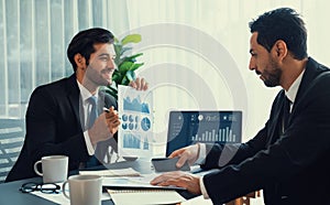 Busy analyst team discussing financial data on laptop and phone. Fervent