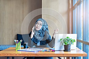 Busy asian muslim business woman talking on mobile phone