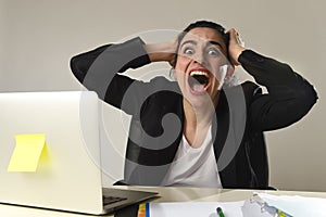 Busy attractive woman in business suit working in stress screaming desperate overwhelmed