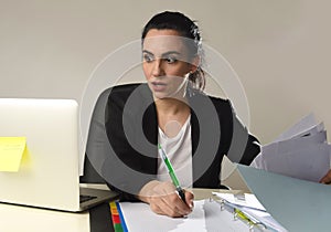 Busy attractive woman in business suit working in stress writing desperate overwhelmed