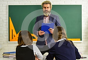 Really busy. back to school. Teacher and pupils working at desk together at the elementary school. disclose and develop