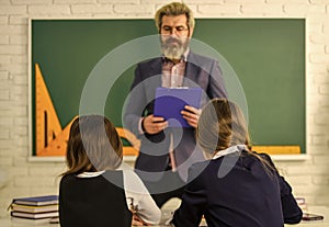 Really busy. back to school. Teacher and pupils working at desk together at the elementary school. disclose and develop