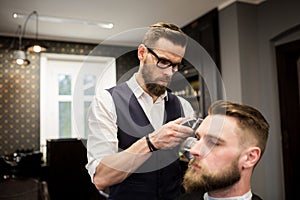 Busy barber shaving customer hair