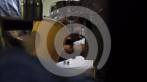 Busy barista hands making coffee behind paper cups in coffee machine.