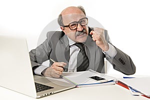 Busy business man with bald head on his 60s working angry and frustrated at office computer laptop desk looking upset