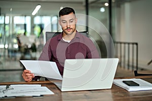 Busy business man lawyer checking documents working at laptop in office.