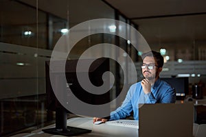Busy business man software developer using computer working late in office.