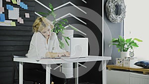 Busy business woman talking on cell phone and working on computer in office