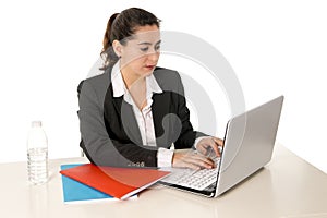 Busy business woman wearing a suit working on laptop