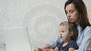 Busy business woman working with baby on lap