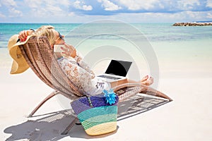 Busy business woman working on the beach