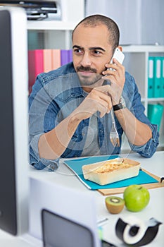 busy businessman eating lunch at office desk