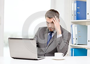 Busy businessman with laptop and coffee