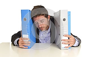 Busy businessman overwhelmed in stress at office exhausted holding paperwork folders