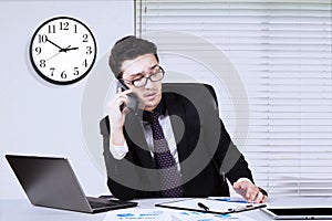 Busy businessman with smartphone and paperwork