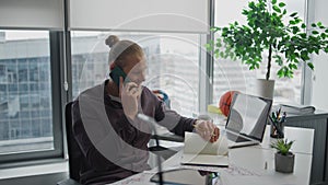 Busy businessman speaking cellphone indoors close up. Positive guy writing notes