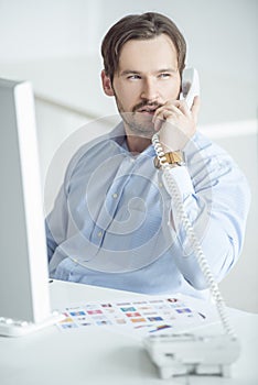 Busy businessman talking phone at his desk