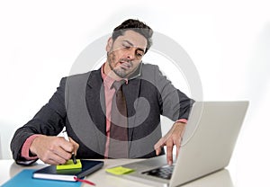 Busy businessman working in stress on computer laptop talking on mobile phone