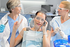 Busy businesswoman at dental surgery on phone