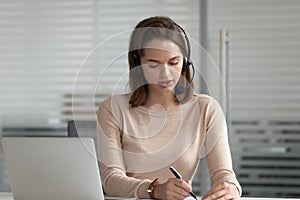 Busy businesswoman in headset consulting client or learning online