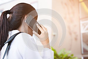 Businesswoman holding mobile phone outside office building. beau