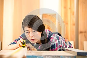 Busy carpenter using a measuring tape