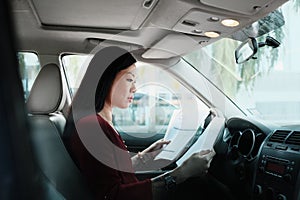 Busy Chinese Business Woman Working In Car With Papers