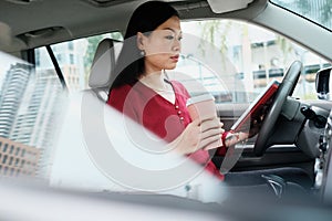 Busy Chinese Business Woman Working In Car With Tablet