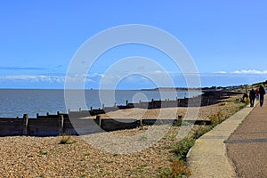 A busy coastal pathway alongside the pebbled beach at Tankerton