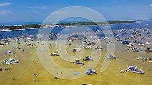 Busy Crab Island near white sandy beaches of Okaloosa Island Grass Flats in Destin, brackish water low tide and pontoons, jet skis