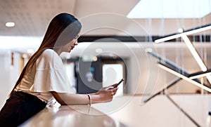 A busy day of networking deserves a break. Shot of a young businesswoman using a smartphone at a conference.