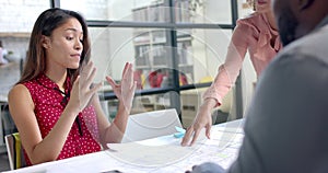 Busy diverse architects discussing blueprints on table in office, slow motion