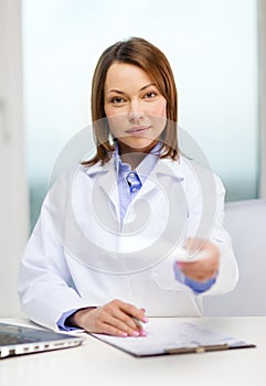 Busy doctor with laptop computer and clipboard