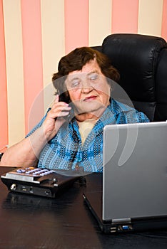 Busy elderly business woman in office