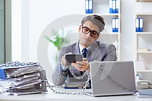 The busy employee chained to his office desk