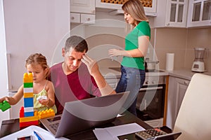 Busy family - Man working with computer while looking after his daughter