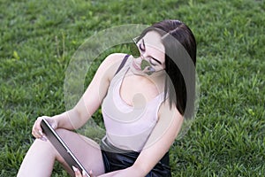Busy fashionably dressed girl on fresh grass