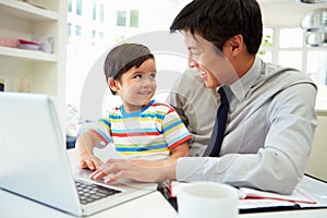 Busy Father Working From Home With Son