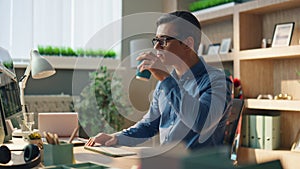 Busy freelancer sipping coffee workplace closeup. Man typing computer keyboard