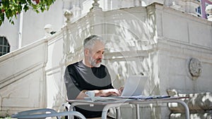 Busy freelancer working park in summer. Focused grey hair man typing computer