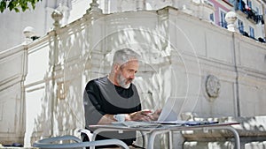 Busy freelancer working park in summer. Focused grey hair man typing computer