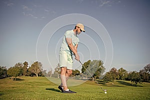 busy golfer in cap with golf club, golf course