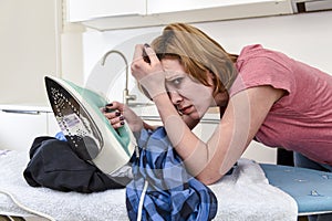 Busy housewife ironing shirt lazy at home kitchen using iron lea